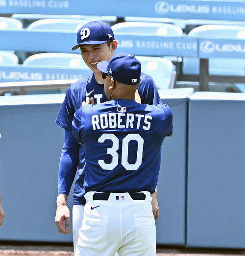 ドジャース対ヤンキース　試合前練習でドジャース佐々木（後方）はロバーツ監督の話を聞く（撮影・滝沢徹郎）