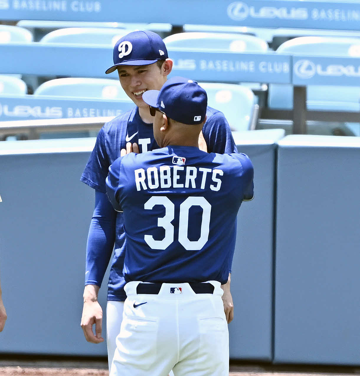 ドジャース対ヤンキース　試合前練習でドジャース佐々木（後方）はロバーツ監督の話を聞く（撮影・滝沢徹郎）