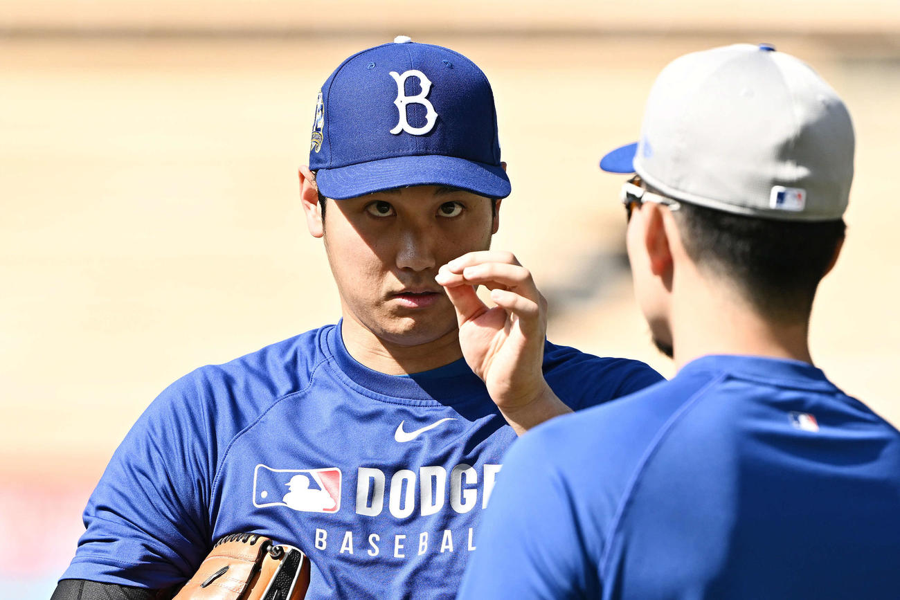 ドジャース対メッツ　試合前練習でメッツ千賀（手前）と談笑するドジャース大谷は帽子を見つめる（撮影・滝沢徹郎）