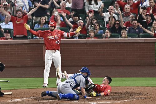 カージナルス対ドジャース　5回裏カージナルス2死二、三塁、ドノバンの2点適時打で生還するヌートバー（右）はラッシングと交錯する（撮影・滝沢徹郎）