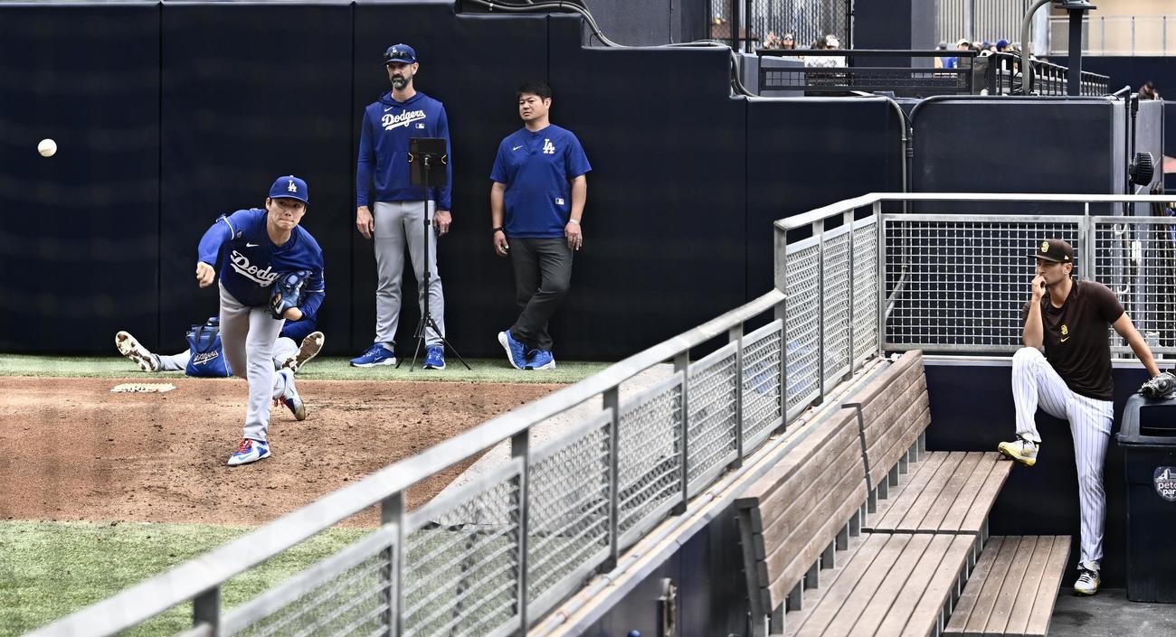 パドレス対ドジャース　試合前のブルペンで投球練習するドジャース山本。右は見守るパドレスのダルビッシュ（撮影・滝沢徹郎）