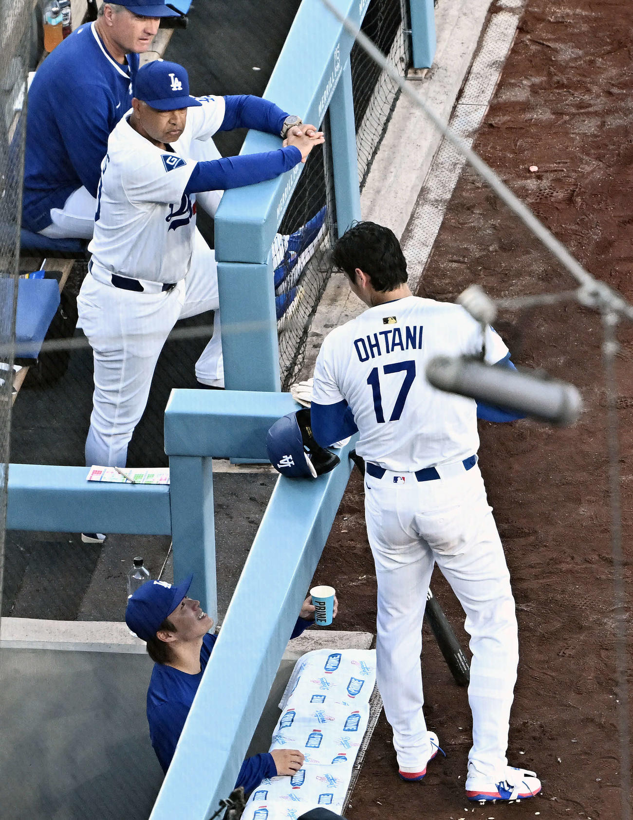 ドジャース対パドレス　1回表を投げ終え打者の準備をするドジャース大谷（中央）に飲み物を差し出す山本（下）。上は見守るロバーツ監督（撮影・滝沢徹郎）