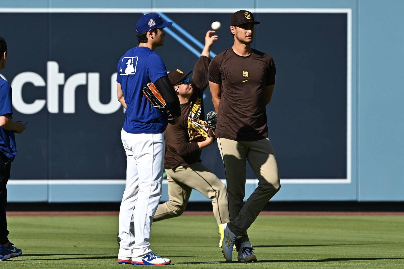 ドジャース対パドレス　試合前練習で談笑するドジャース大谷（左）とパドレスのダルビッシュ。後方はキャッチボールする松井（撮影・滝沢徹郎）