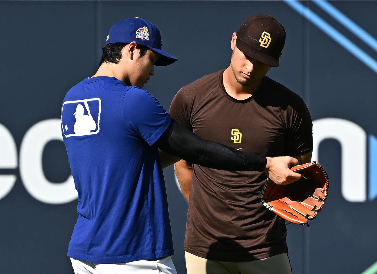 ドジャース対パドレス　試合前練習でドジャース大谷（左）はサポーターを付けた腕をパドレスのダルビッシュに見せる（撮影・滝沢徹郎）