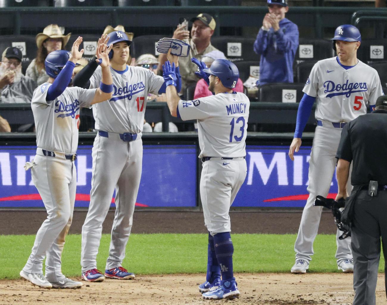 ロッキーズ戦の7回、満塁本塁打を放ったマンシーとタッチを交わすドジャース大谷（左から2人目）＝デンバー（共同）