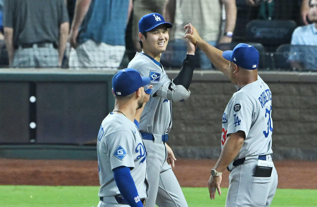 ロイヤルズ対ドジャース　試合後、笑顔でタッチを交わすドジャース大谷（中央）とロバーツ監督（撮影・滝沢徹郎）