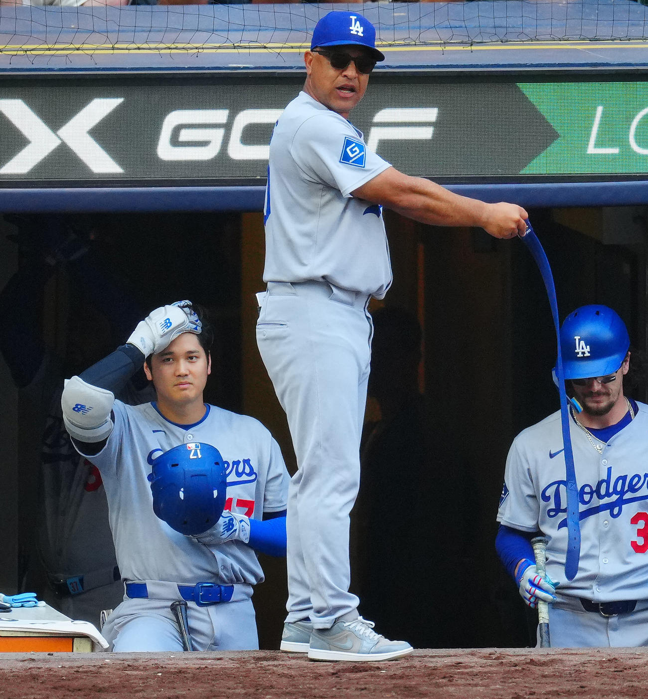 ブルワーズ対ドジャース　7回表ドジャース無死、遊撃内野安打で出塁するもベルトが切れたロハスのために自身のベルトを外しスタッフに渡しに行かせるロバーツ監督（中央）。左は大谷（撮影・垰建太）
