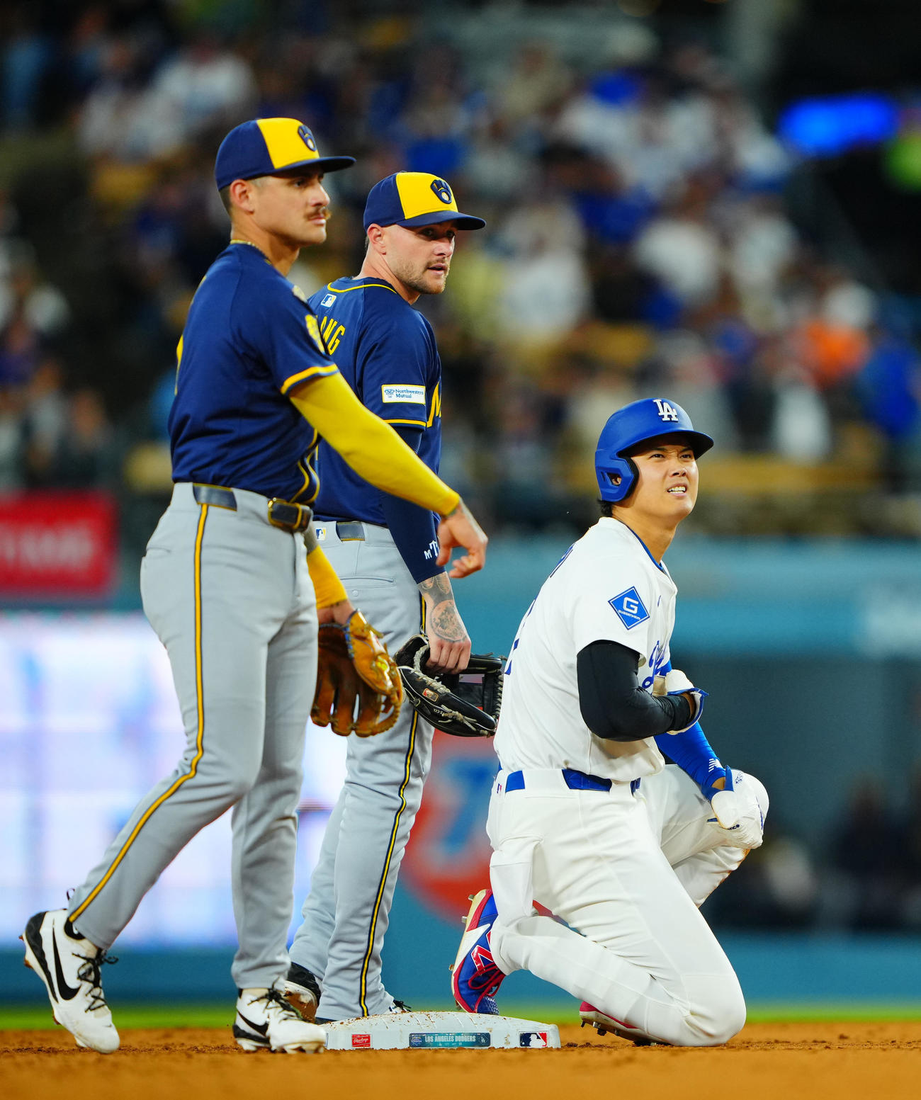 ドジャース対ブルワーズ　6回裏ドジャース2死一塁、チュラング（左）と交錯しながらも二盗を決めた大谷はお腹を痛そうにおさえる（撮影・垰建太）