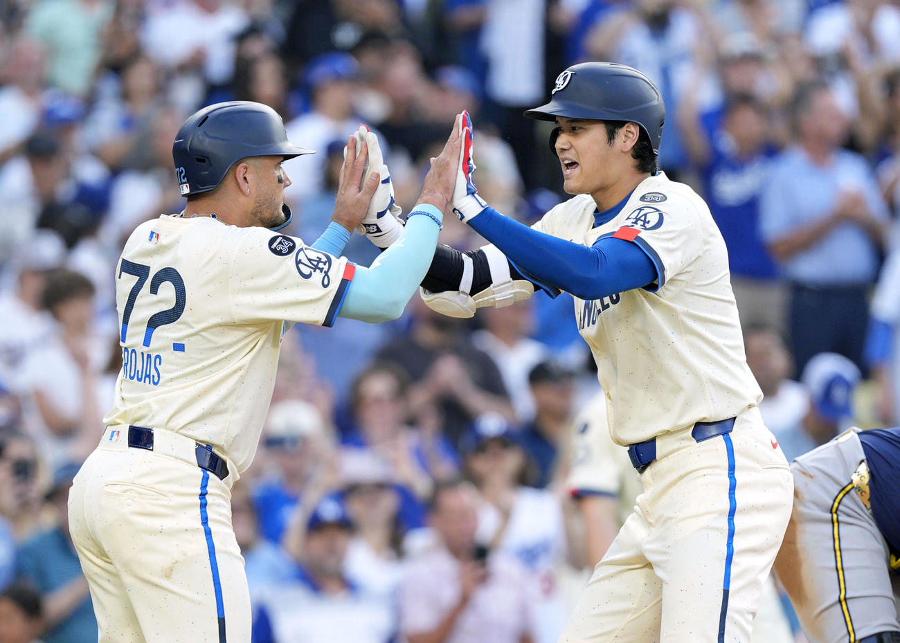 ブルワーズ戦の3回、33号2ランを放ちロハス（左）に迎えられるドジャース大谷（共同）