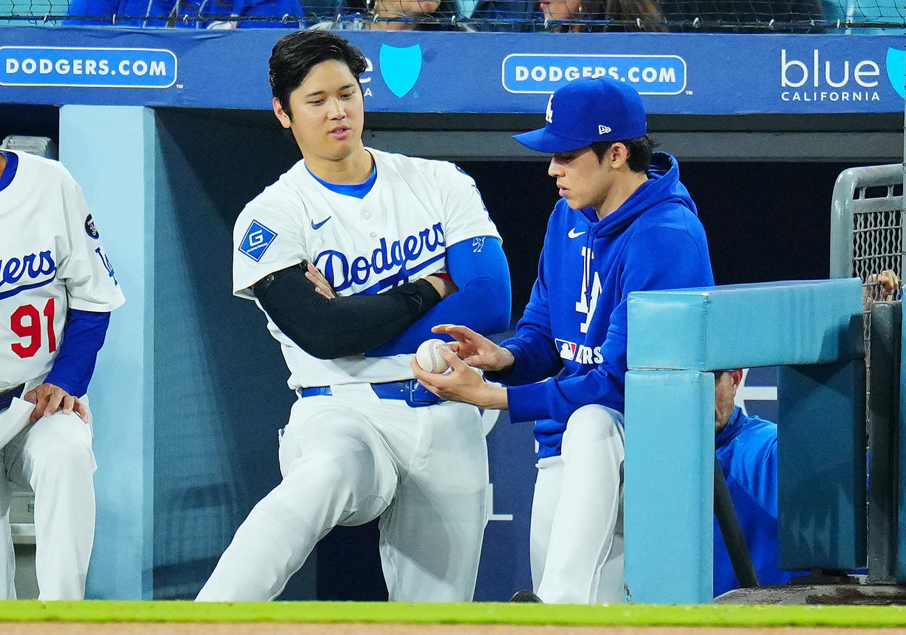ドジャース対ツインズ　ベンチでボールを手にするドジャース佐々木（右）と話す大谷（撮影・垰建太）