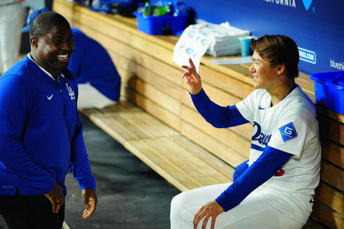 ドジャース対ツインズ　5回表の登板を終えベンチでひと息つくドジャース先発の山本（右）を笑わせるスミス・コーチ（撮影・垰建太）