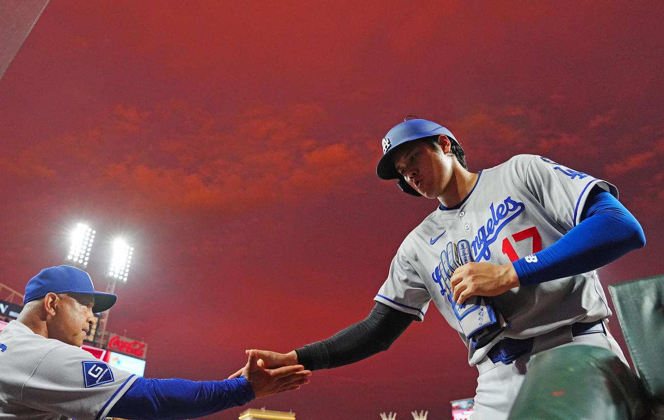 レッズ対ドジャース　7回表ドジャース無死一、三塁、フリーマンの適時打で生還しロバーツ監督（左）とタッチを交わす大谷（撮影・垰建太）