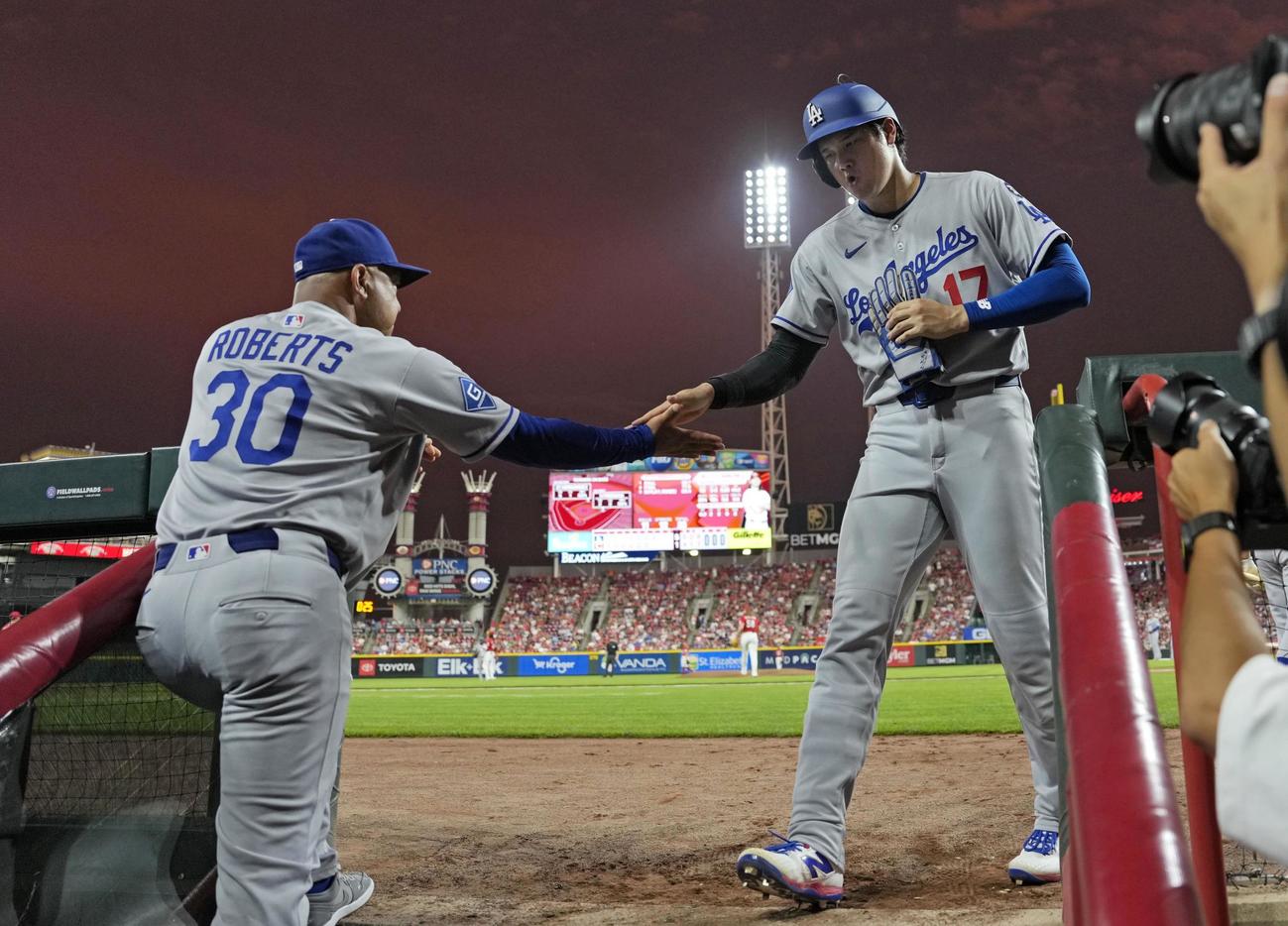 レッズ戦の7回、フリーマンの適時打で生還しロバーツ監督とタッチを交わすドジャース大谷（共同）