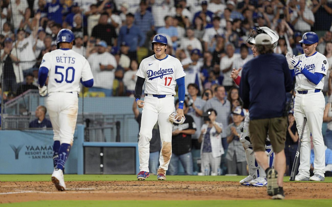 ブルージェイズ戦の5回、逆転2ランを放ったベッツ（50）を迎える、先に生還したドジャース二走の大谷。右端は次打者フリーマン（共同）