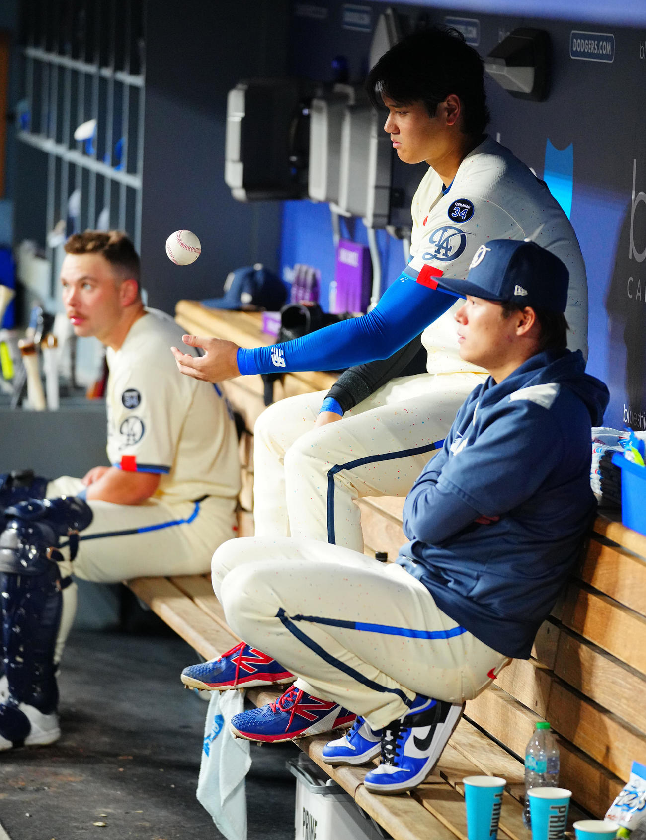 ドジャース対ブルージェイズ　ドジャース大谷（中央）はベンチでボールを手に山本と言葉を交わす（撮影・垰建太）