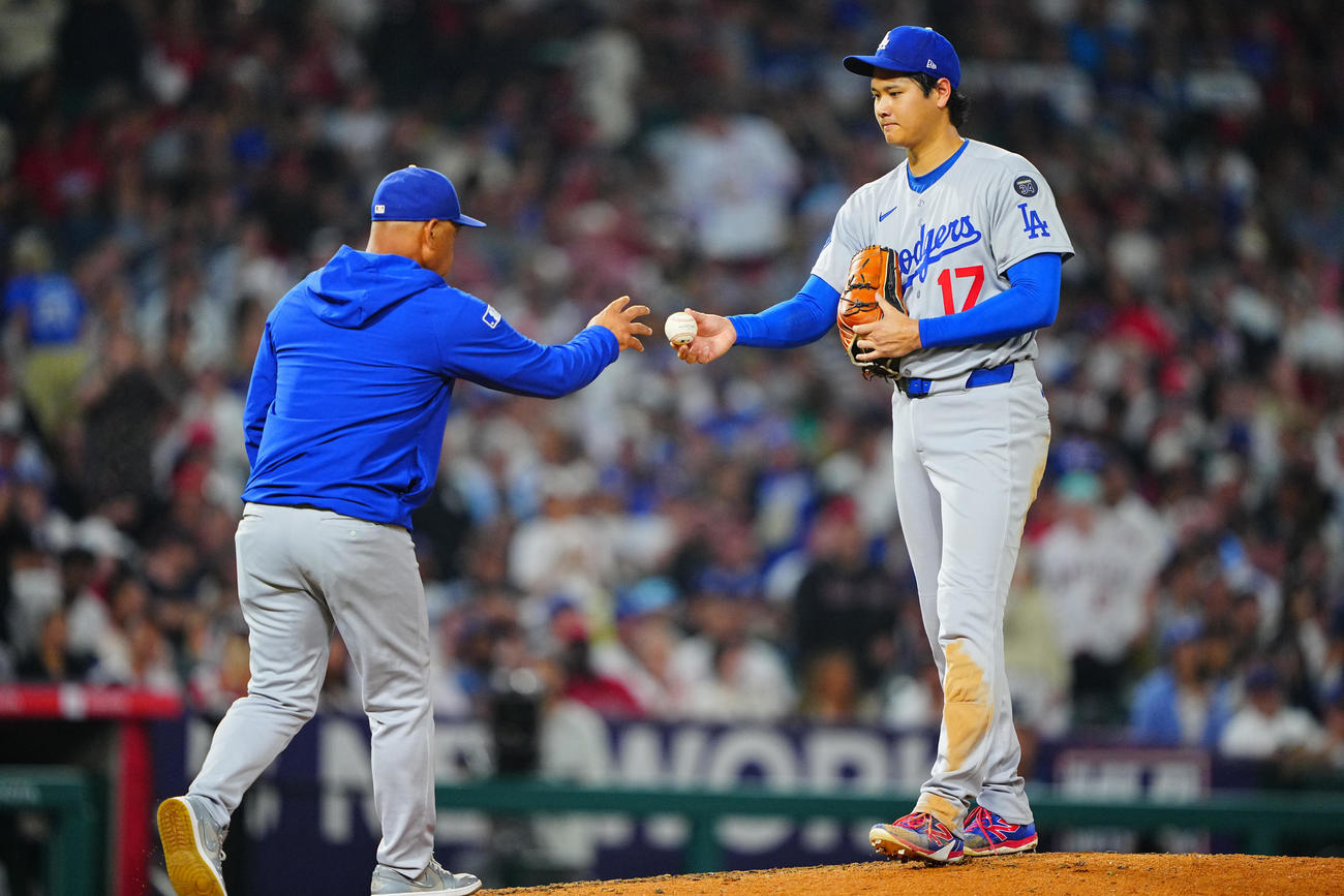 エンゼルス対ドジャース　5回裏ドジャース1死二塁、交代を告げに来たロバーツ監督（左）にボールを渡す大谷（撮影・垰建太）