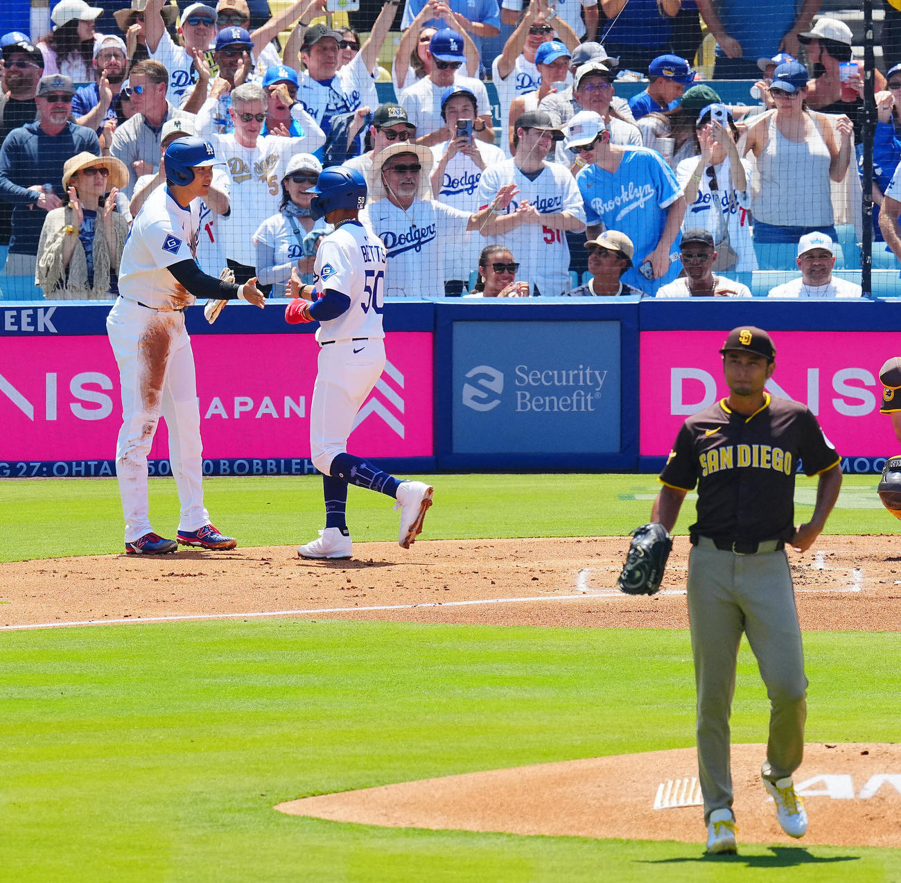 ドジャース対パドレス　1回裏ドジャース1死一、二塁、フリーマンの3点本塁打で生還しタッチを交わす大谷（左）とベッツ。投手ダルビッシュ（撮影・垰建太）