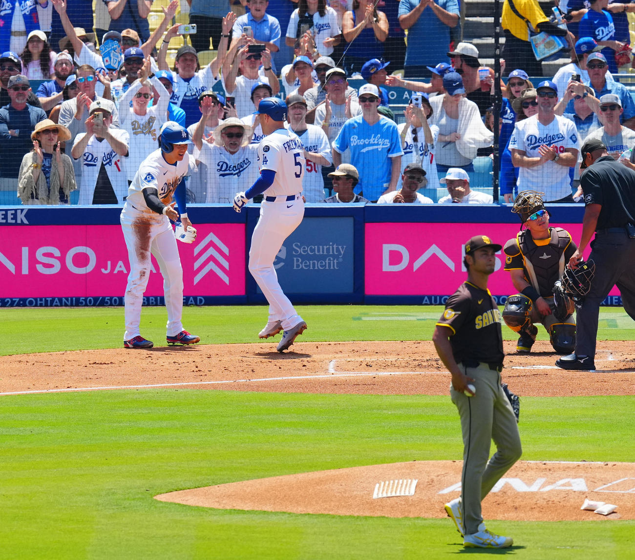 ドジャース対パドレス　1回裏ドジャース1死一、二塁、先制3点本塁打を放ったフリーマン（中央）と笑顔でタッチを交わす大谷（左）。投手ダルビッシュ（撮影・垰建太）