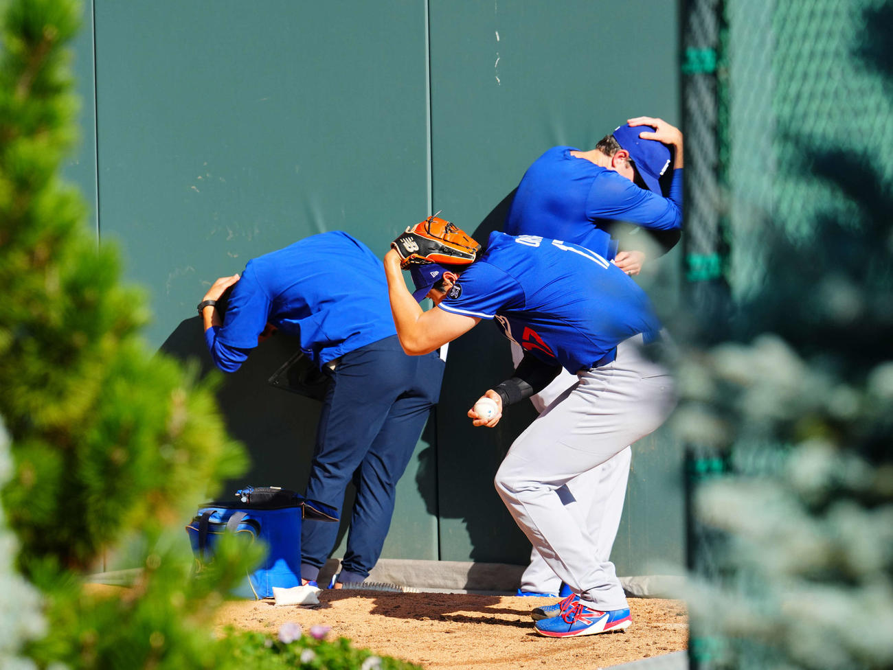 ロッキーズ対ドジャース　試合前ブルペンでの練習中、打撃練習の打球が飛んできたと思い身をかがめるドジャース大谷とスタッフ（撮影・垰建太）