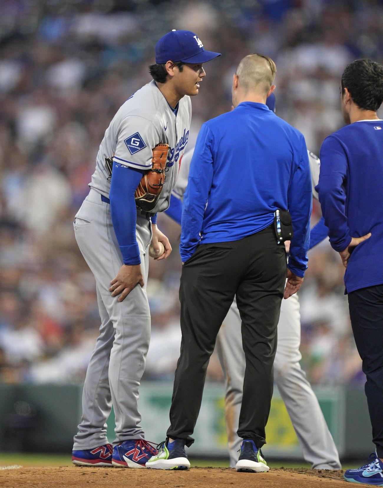 ロッキーズ戦の4回、打球が当たり、チームスタッフと話すドジャース大谷（共同）