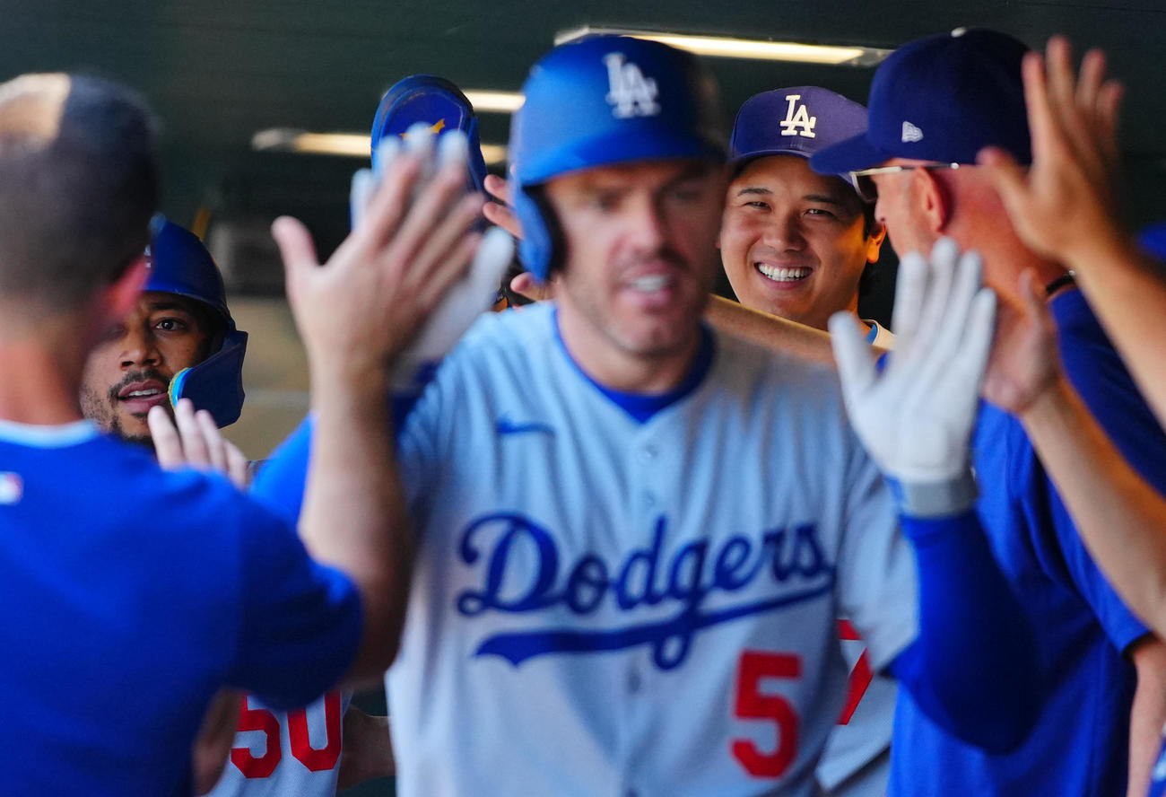 ロッキーズ対ドジャース　1回表ドジャース無死一塁、先制2点本塁打を放ったフリーマン（手前）とベッツ（左）を笑顔で迎える大谷（撮影・垰建太）