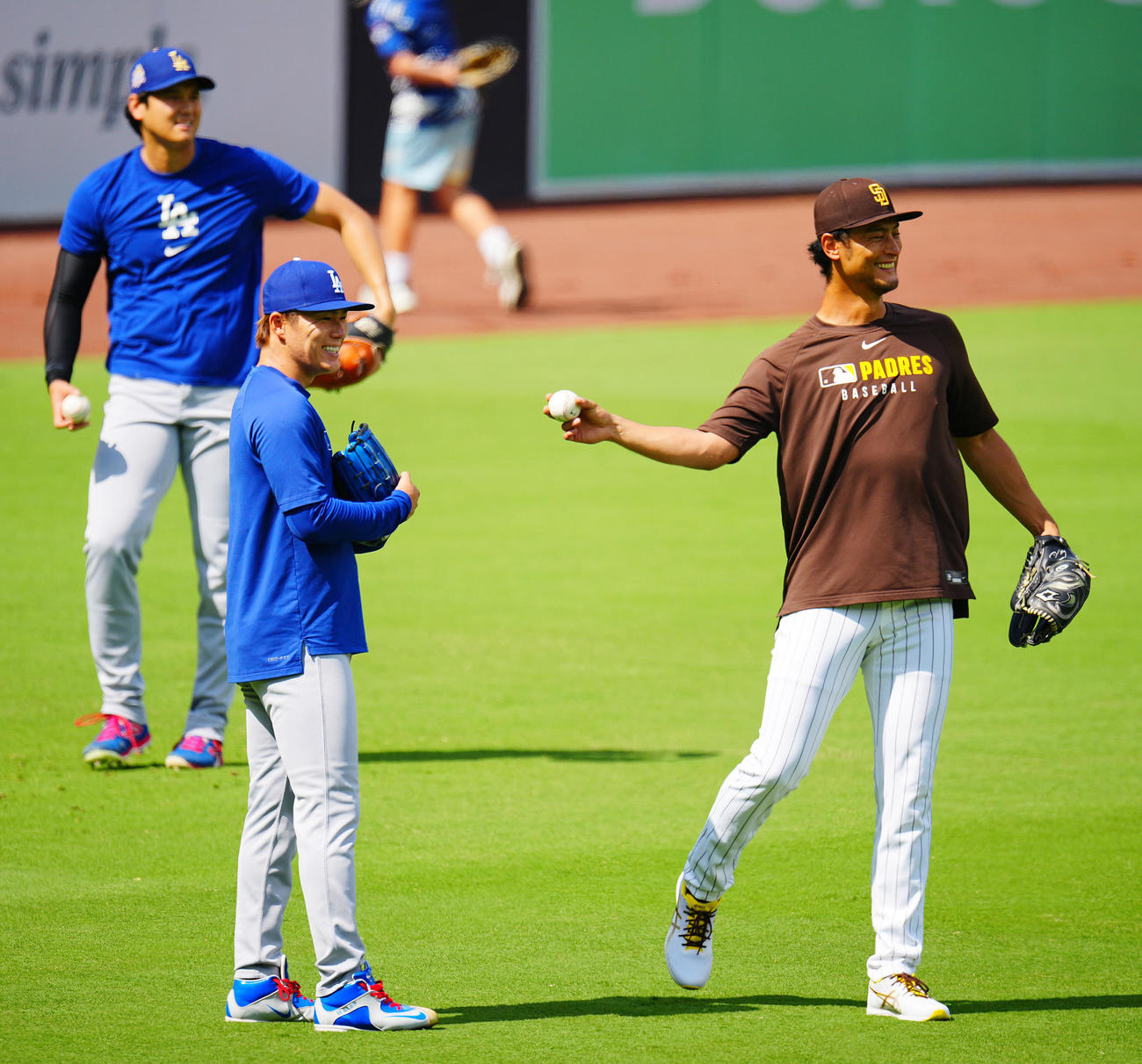 パドレス対ドジャース　試合前練習中、談笑するパドレスのダルビッシュ（右）とドジャース山本。後方は大谷（撮影・垰建太）
