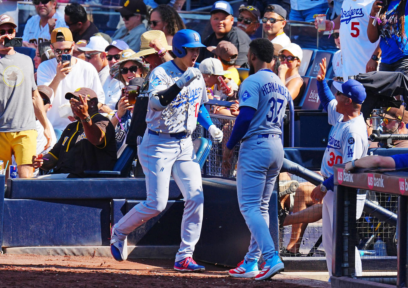 パドレス対ドジャース　9回表ドジャース1死、ソロ本塁打を放った大谷（中央左）はパドレスファン（左）とタッチを交わし恒例のヒマワリの種を浴びる（撮影・垰建太）