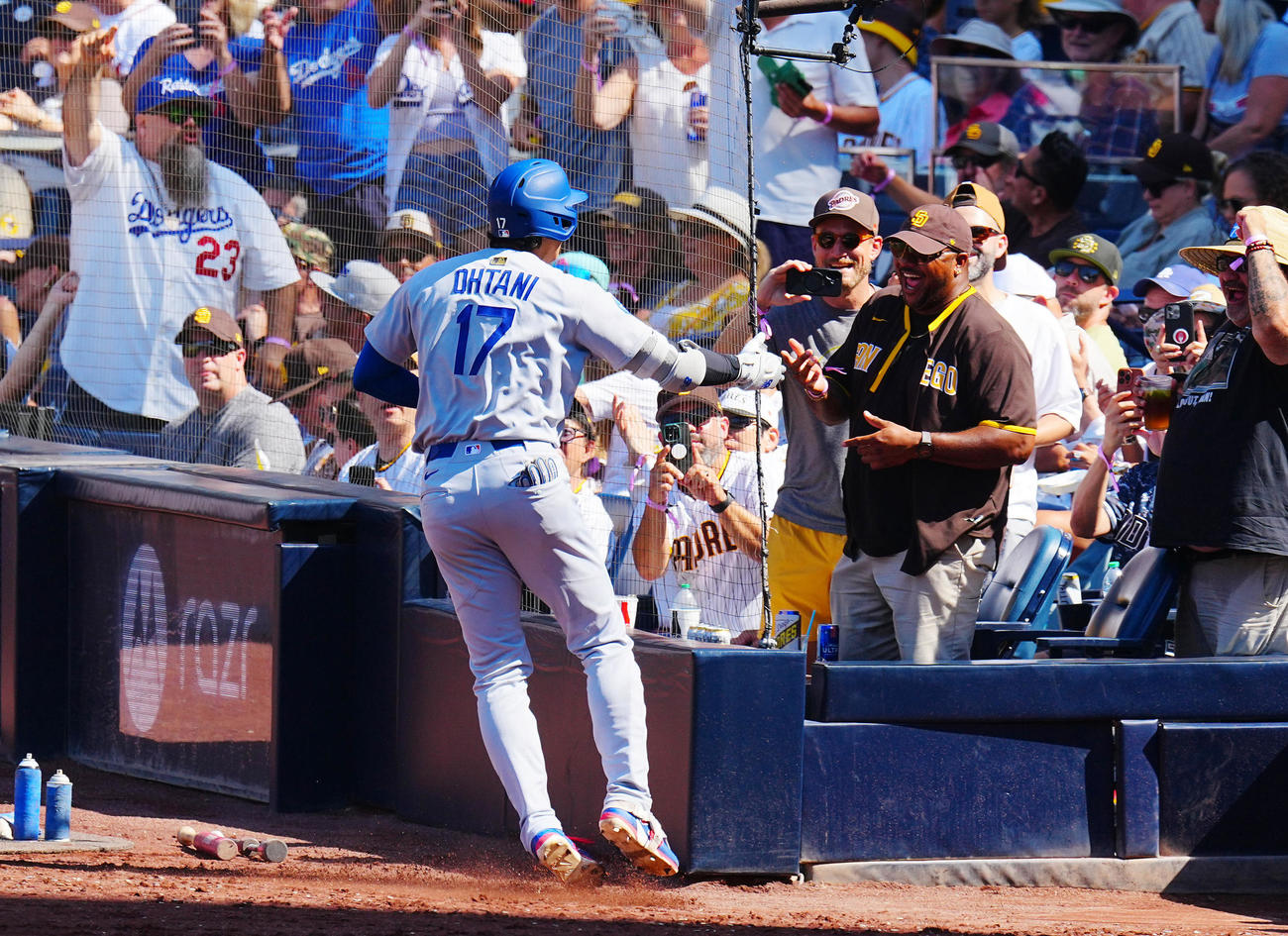 パドレス対ドジャース　9回表ドジャース1死、ソロ本塁打を放った大谷（左）はベンチ前でパドレスファンとタッチを交わす（撮影・垰建太）