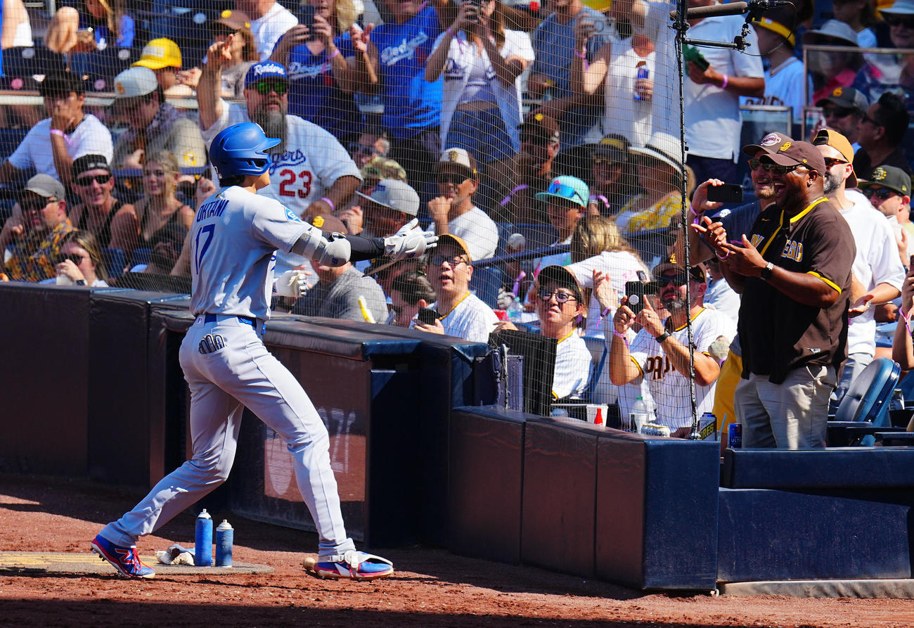 パドレス対ドジャース　9回表ドジャース1死、ソロ本塁打を放った大谷（左）はベンチ横のパドレスファンとタッチを促す（撮影・垰建太）