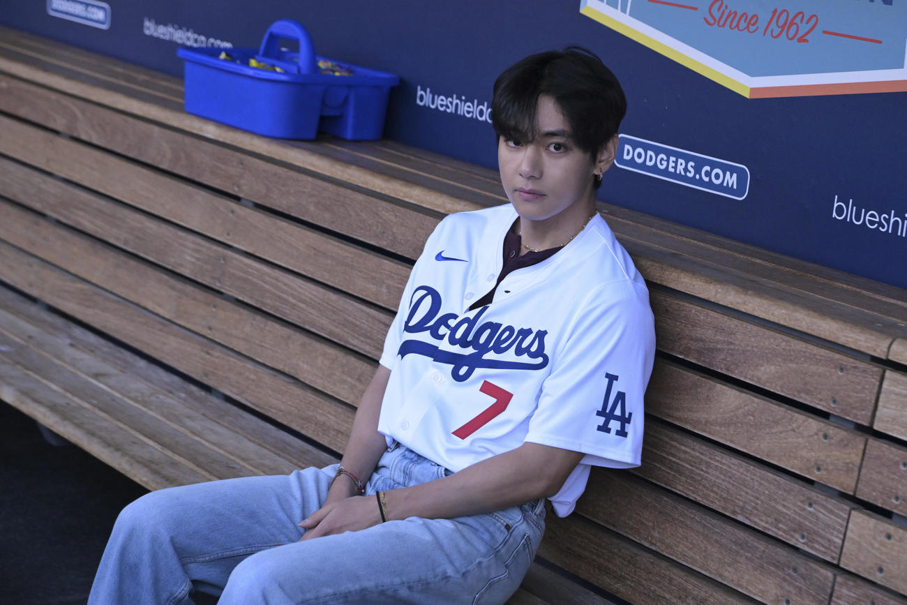 ドジャースとレッズの試合前にベンチに座るBTSメンバーのV＝2025年8月25日（AP)
