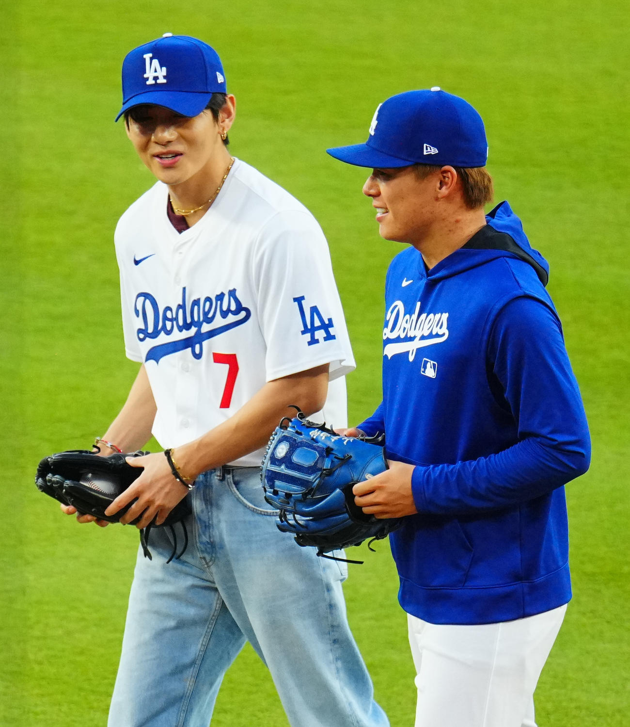 25年8月25日　ドジャース対レッズ　始球式を終えたBTSのV（左）と捕手を務めた山本は笑顔で談笑（撮影・垰建太）