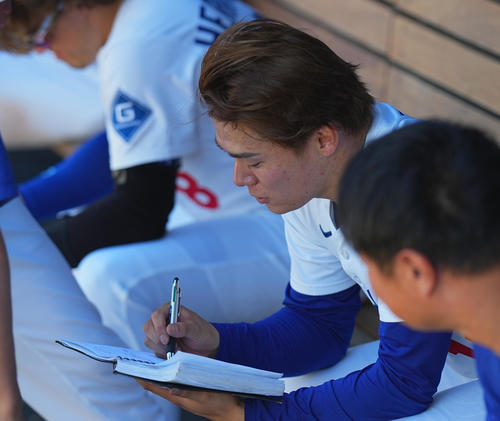 ドジャース対ダイヤモンドバックス　試合中、ベンチでノートに書き込むドジャース山本（撮影・菅敏）