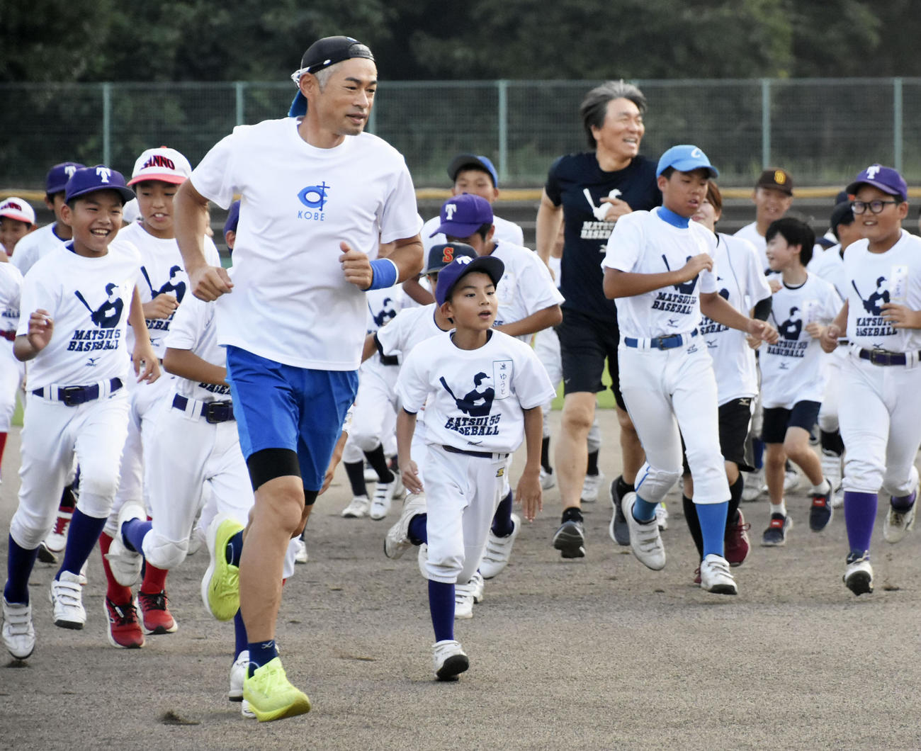 野球教室で子どもたちとランニングするイチローさん（左）と松井さん（奥）（共同）