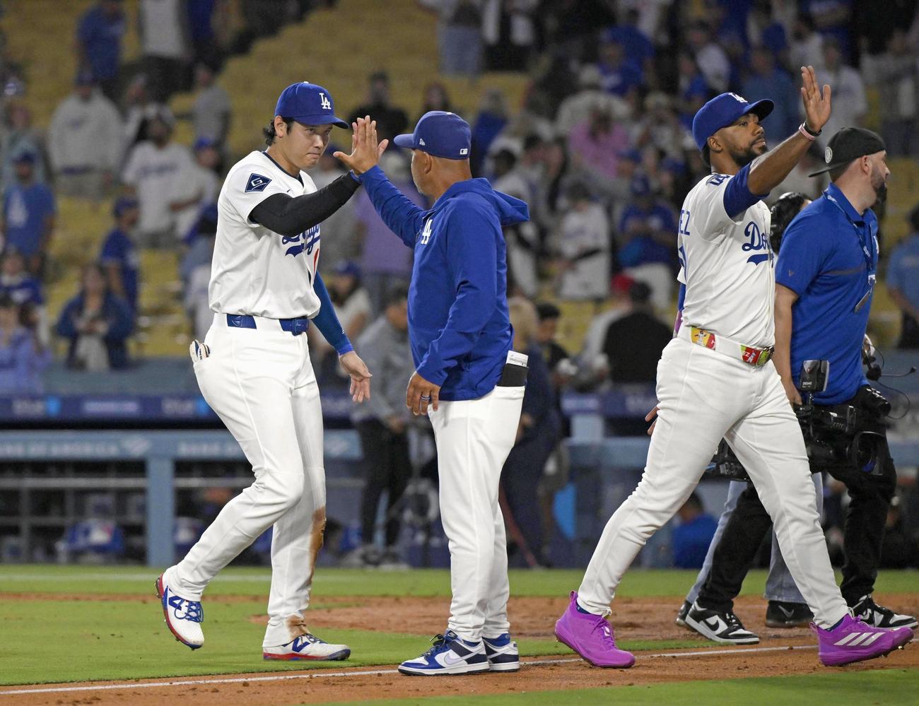 ロッキーズに勝利し、ロバーツ監督とタッチを交わすドジャース大谷（左端）（共同）