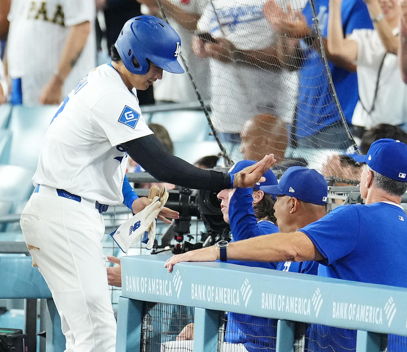 ドジャース対ロッキーズ　2回裏ドジャース2死一塁、ベッツの適時二塁打で一塁から疾走し、ロバーツ監督（右から2人目）にタッチで迎えられる大谷（撮影・菅敏）