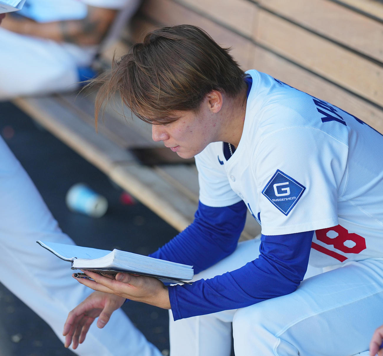 ドジャース対ダイヤモンドバックス　試合中、ベンチでノートを読むドジャース山本由（撮影・菅敏）