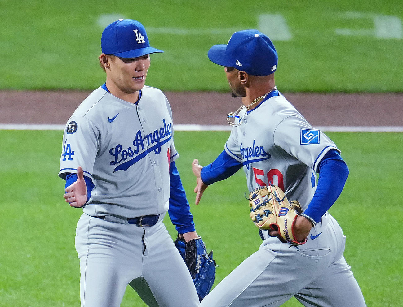 ジャイアンツ対ドジャース　2回の投球を終え、ベッツ（右）をタッチで迎える山本（撮影・菅敏）