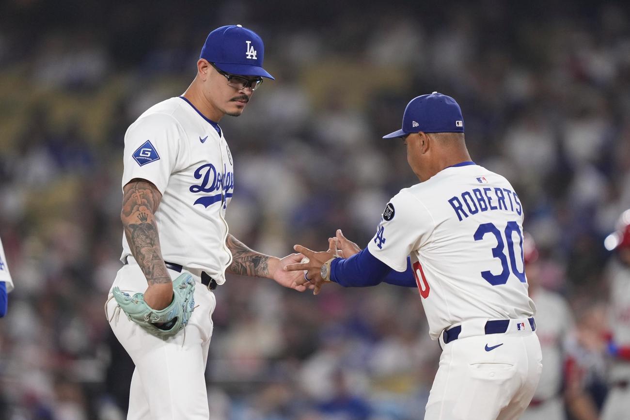 交代を告げられたドジャースのバンダ（左）はロバーツ監督にボールを手渡す（AP)