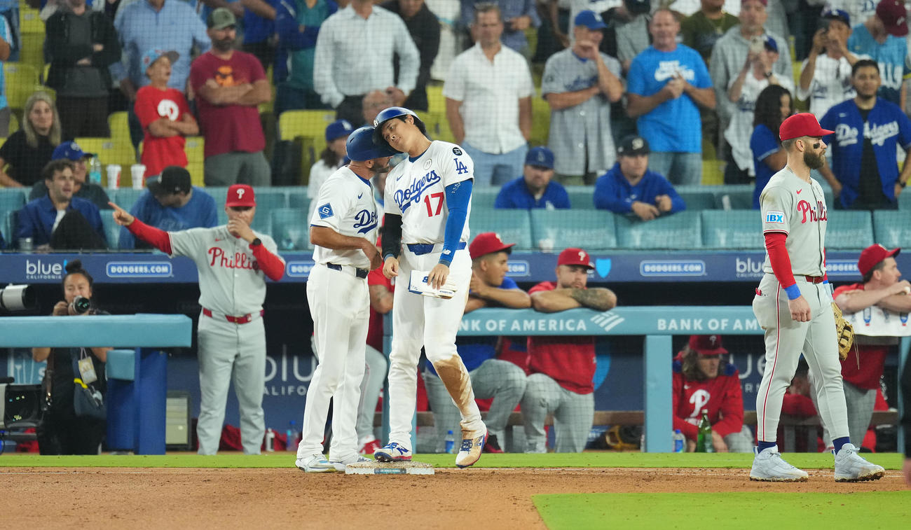 ドジャース対フィリーズ　9回裏ドジャース2死、四球を選び一塁走塁コーチとヘッドバンプする大谷。右はハーパー（撮影・菅敏）
