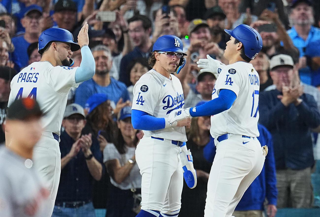 ドジャース対ジャイアンツ　5回裏ドジャース2死一、二塁、左越えに52号3点本塁打を放ち、パペス（左）とK・ヘルナンデス（中央）に迎えられる大谷（撮影・菅敏）