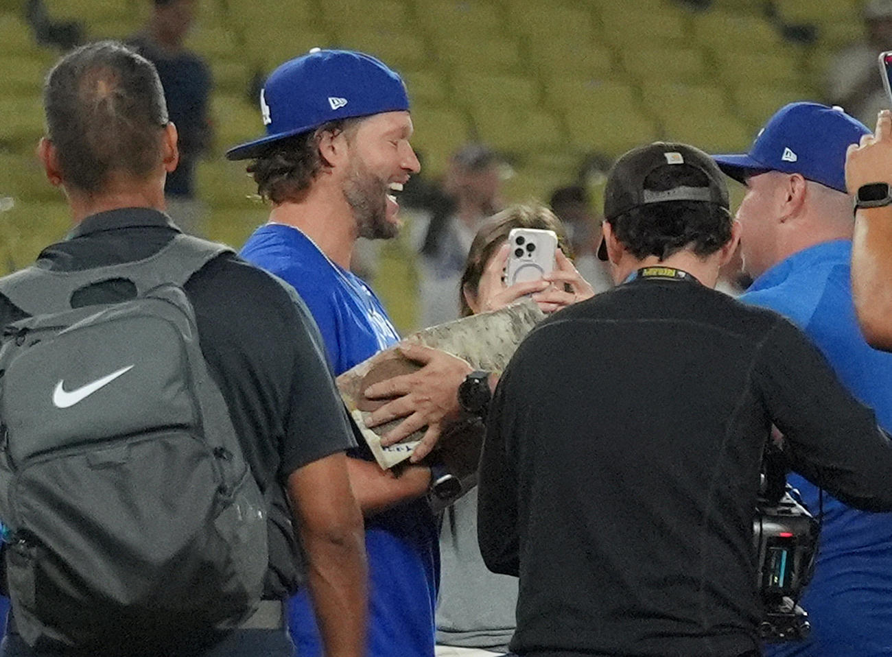ドジャース対ジャイアンツ　試合後、掘り起こしたマウンドのプレートを受け取り、笑顔の見せるドジャース・カーショー（中央）（撮影・菅敏）