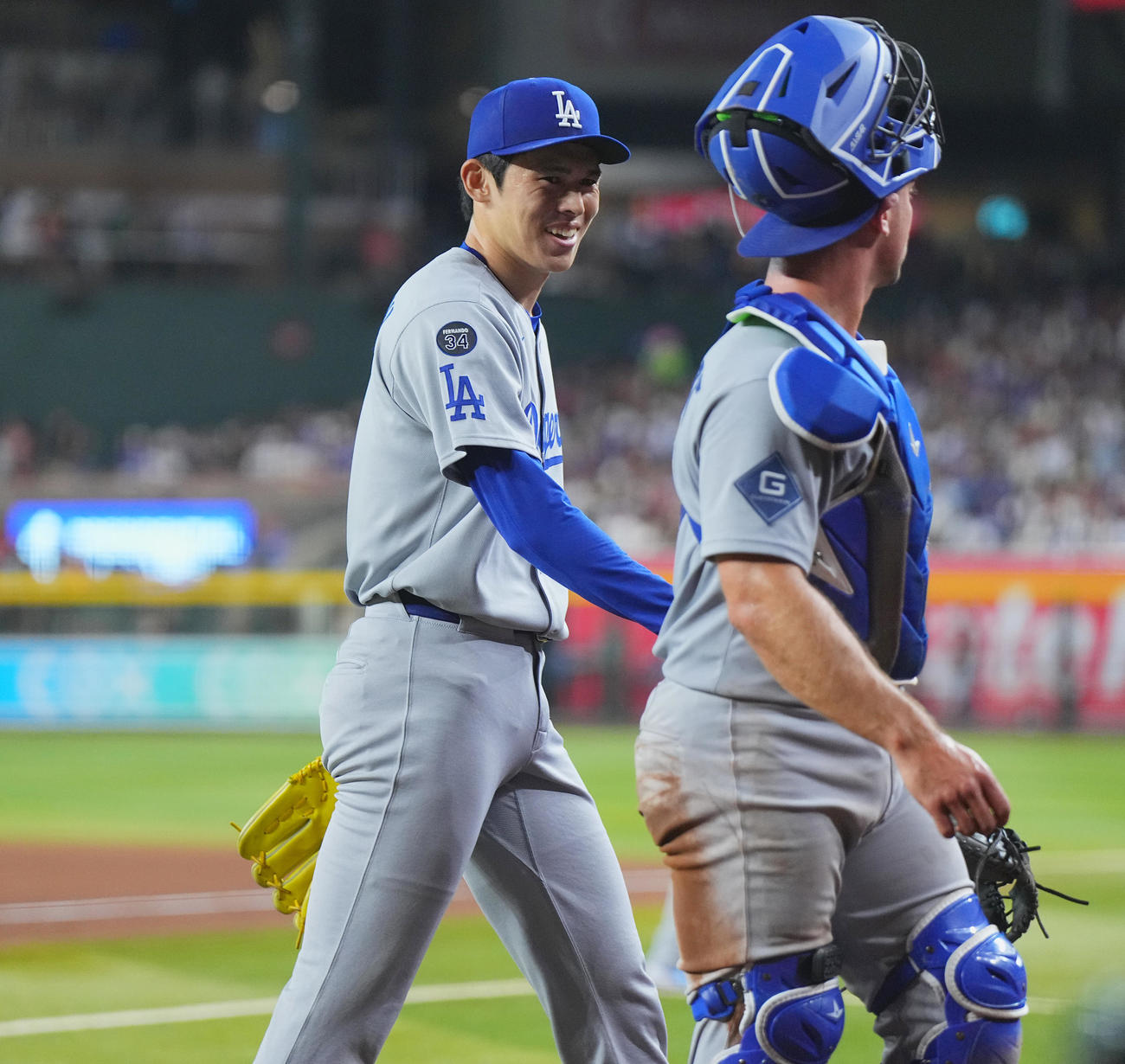 ダイヤモンドバックス対ドジャース　7回、リリーフで登板し、3者凡退に抑えたドジャース佐々木は、笑顔で引き揚げる。手前は捕手ロートベット（撮影・菅敏）