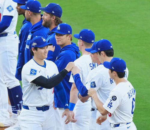 ワイルドカード・ドジャース対レッズ第1戦　試合前のセレモニーでコールされ、佐々木（右から2人目）とタッチをする大谷。後方左から4人目は山本（撮影・菅敏）