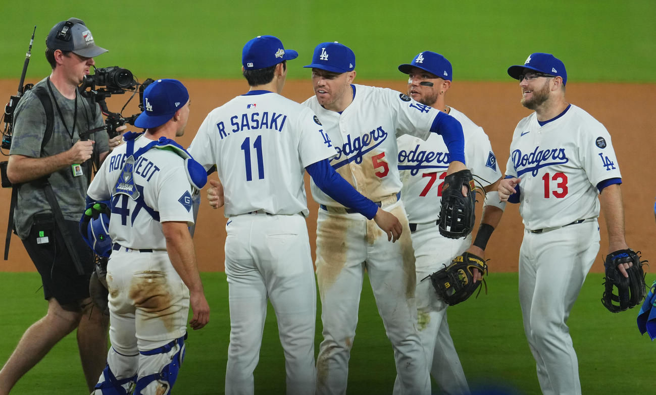 ドジャース対レッズ　地区シリーズ進出を決め、フリーマン（中央）とハグする佐々木（撮影・菅敏）