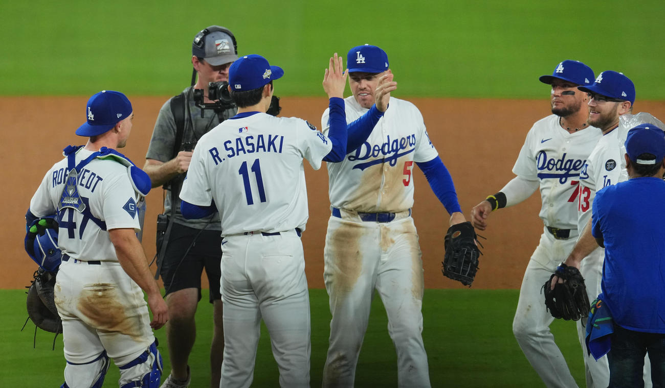 ドジャース対レッズ　地区シリーズ進出を決め、フリーマン（中央）とタッチをする佐々木（撮影・菅敏）