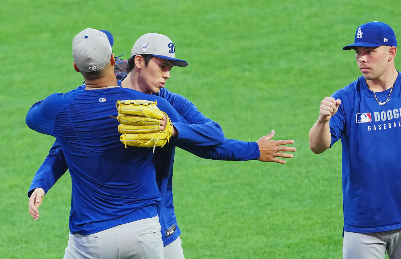 地区シリーズフィリーズ対ドジャース　前日練習に参加しキャッチボールを終えたドジャース佐々木（中央）は、同僚とハグする（撮影・菅敏）