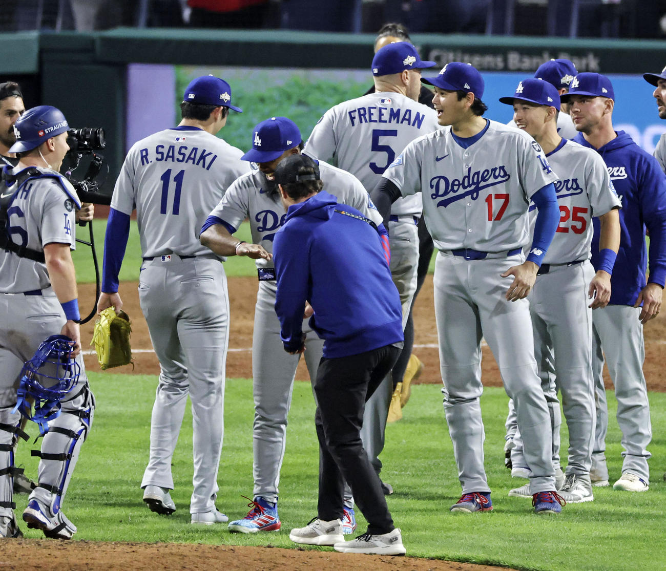 フィリーズとの地区シリーズ第1戦に勝利し、初セーブを挙げた佐々木朗希を迎える、勝ち投手になったドジャースの大谷翔平（共同）