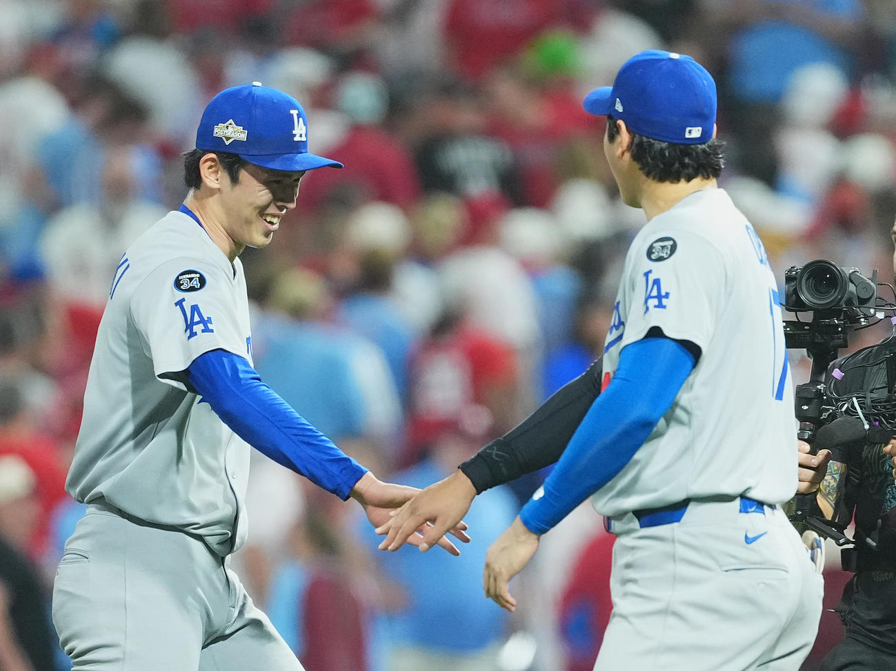 地区シリーズ・フィリーズ対ドジャース　9回に登板し、最後を締めくくった佐々木（左）をタッチで迎える大谷（撮影・菅敏）