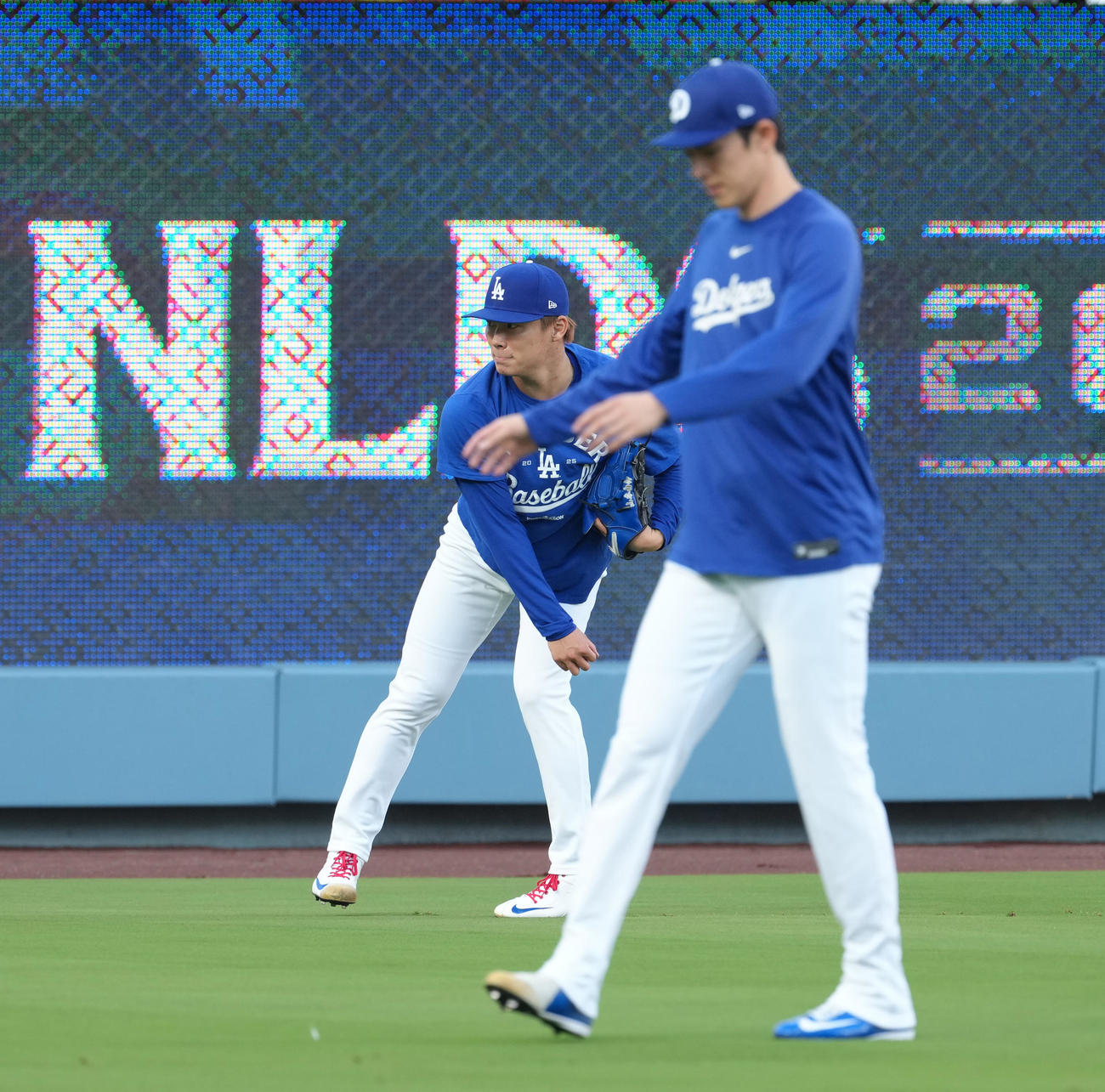 地区シリーズ・ドジャース対フィリーズ　前日練習で調整する佐々木（手前）を前にキャッチボールをするドジャース山本（撮影・菅敏）