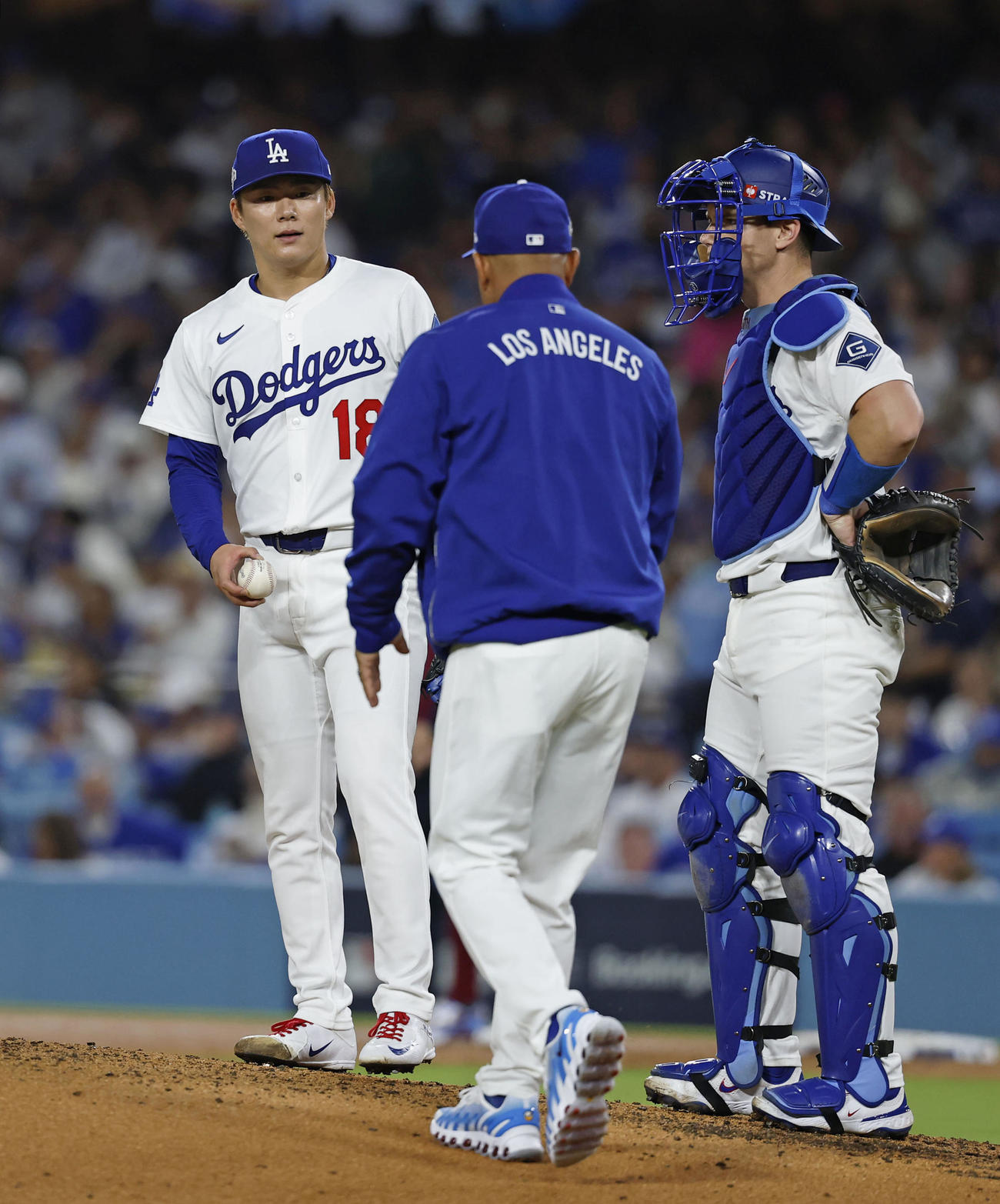 フィリーズ戦の5回途中、ロバーツ監督（中央）に降板を告げられるドジャース先発の山本（共同）